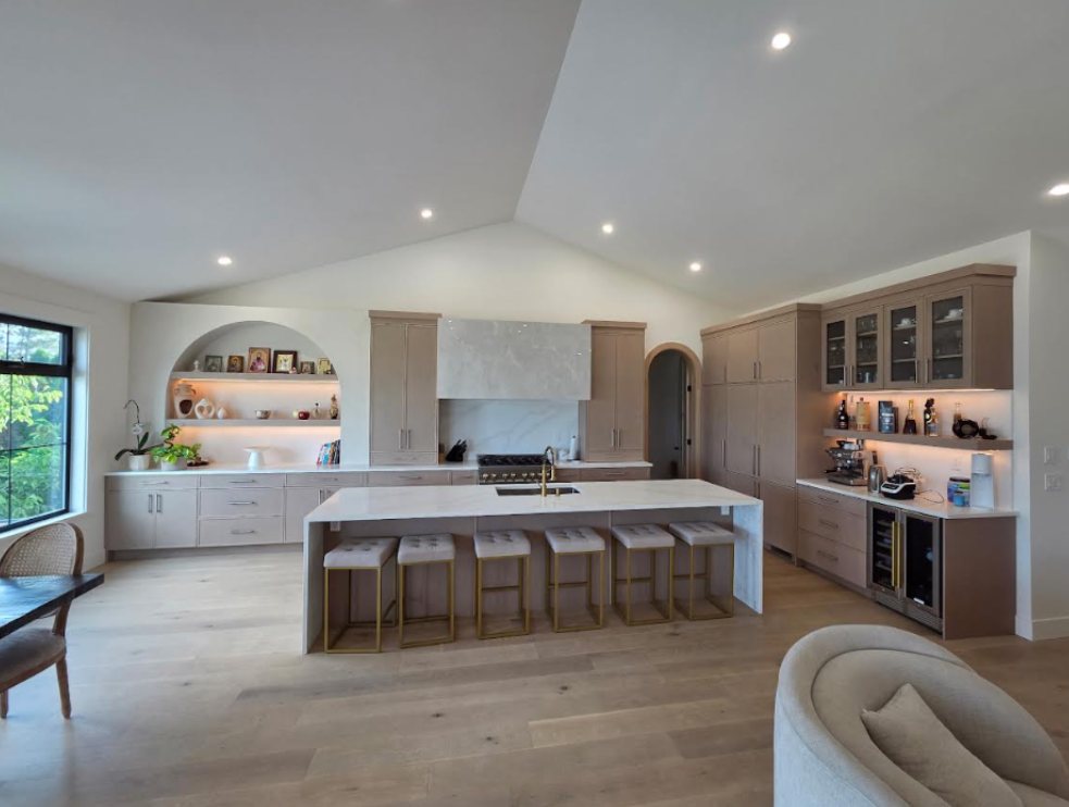 Large open-plan kitchen with painted cabinetry and vaulted ceiling